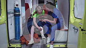 Young nurse and sick girl in ambulance car.