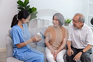 Young nurse taking care elderly people sitting on a sofa