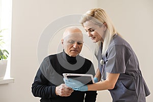 Young nurse taking care of old sick man