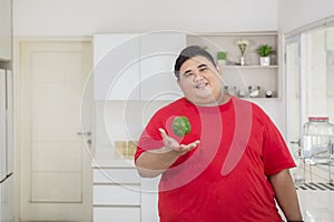 Young obese man preparing to make a salad