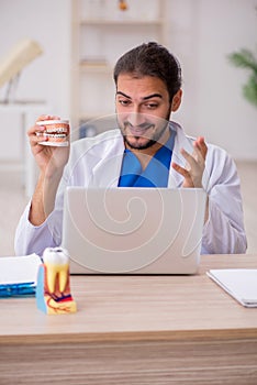 Young male odontologist in telemedicine concept photo