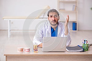 Young male odontologist in telemedicine concept photo