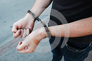 Young offender in handcuffs on wrists