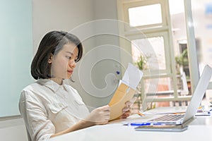 Young office woman reading financial document