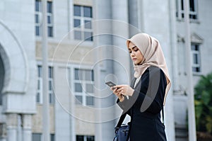Young Office Woman Texting to Someone on her Mobile Phone with Happy Facial Expression