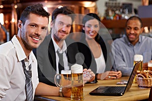 Young office worker drinking beer at pub