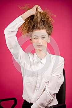 Young office worker fixing her curly long light hair