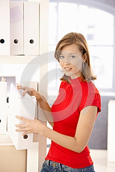 Young office worker organizing folders photo