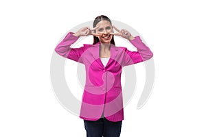 young office worker woman with black hair dressed in a pink jacket looks happy