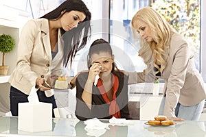 Young office workers comforting crying colleague photo