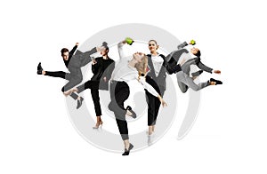 Young office workers dancing in busness style clothes or suit with coffee and gadgets on white background. Creative