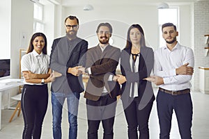 Young office workers or startuppers standing together holding hands looking at camera