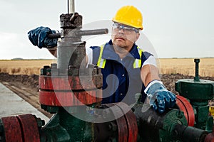 Oil worker is turning valve on the oil pipeline. Oil and Gas Industry.