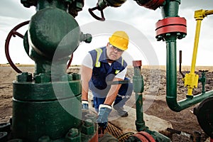 Oil worker is turning valve on the oil pipeline. Oil and Gas Industry.