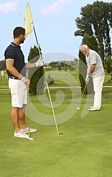 Young and old man golfing together