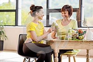 Young and older women with healthy food indoors