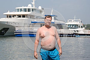 A young oligarch swims in the sea against the background of his own photo