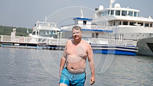 A young oligarch swims in sea against the background photo
