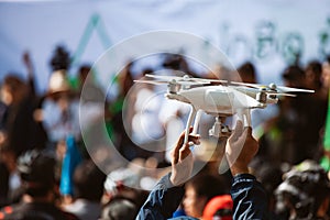 Young operator holding drone above crowd