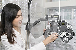 Young ophthalmologist doing visual test for customer using Bifocal Optometry eyesight measurement device in optical center, photo