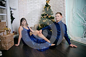 Young ordinary family of two. Young husband and wife near christmas tree. Happy young hetero couple decorate christmas tree at