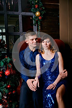 Young ordinary family of two. Young husband and wife near christmas tree. Happy young hetero couple decorate christmas tree at