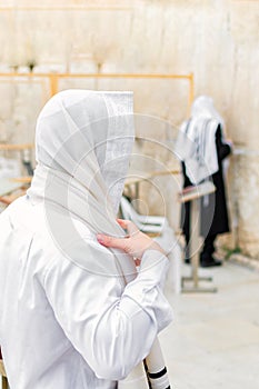 Young Orthodox Jewish man praying with a shawl & x28;tallit& x29;, at the Western Wall.