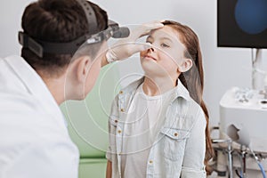 Young otorhinolaryngologist examining nose of his patient