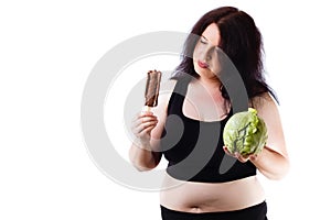 Young overweight food addicted woman choosing between junk and h