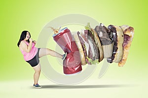 Young overweight woman kicking junk foods