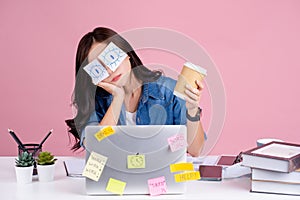 Young overworked Asian woman wearing a casual shirt.. She was sitting at her desk with stickers covering her eyes and using her