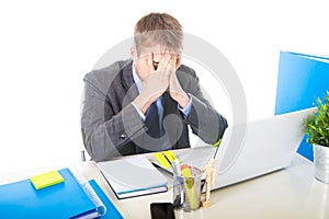 Young overworked and overwhelmed businessman covering his face suffering stress and headache