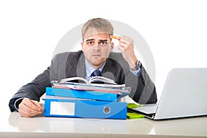 Young overworked and overwhelmed businessman in stress leaning on office folder exhausted and depressed