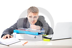 Young overworked and overwhelmed businessman in stress leaning on office folder exhausted and depressed