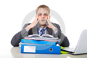 Young overworked and overwhelmed businessman in stress leaning on office folder exhausted and depressed