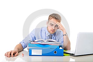 Young overworked and overwhelmed businessman in stress leaning on office folder exhausted and depressed