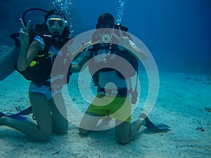 Young pair on the seafloor while diving photo