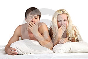 Young pair it yawns lying on the bed photo