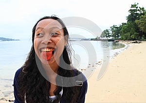 Young Papuan woman with tongue red from betel