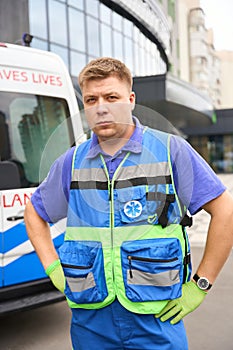 Young paramedic stands by an ambulance