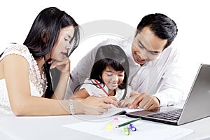 Young parent teaching their daughter to draw