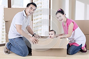 Young parents and child playing with box