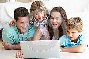 Young parents, with children, on laptop computer