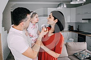 Young parents feed their one year old daughter