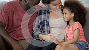 Young parents find approach to shy adopted child, loving and caring family photo
