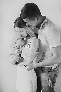 Young parents hold their newborn daughter