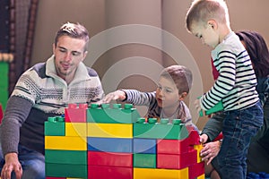 Young parents and kids having fun at childrens playroom