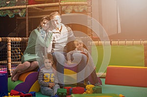 Young parents and kids having fun at childrens playroom