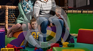 Young parents and kids having fun at childrens playroom