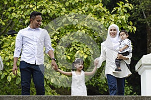 Young parents spending time with their children at park during weekend